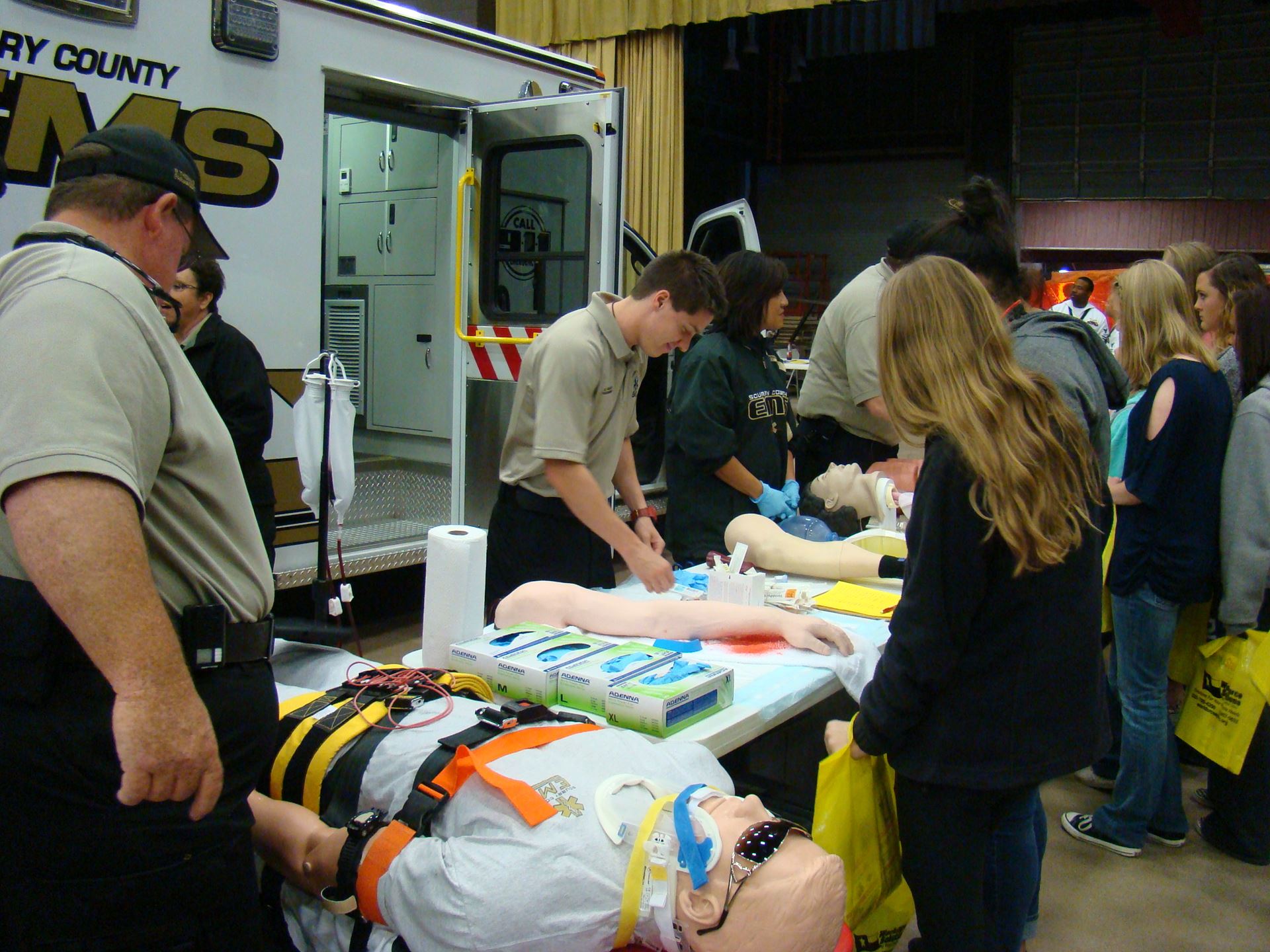 Students explore training dummies at EMS booth.